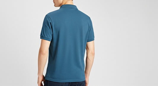 Person wearing a blue polo shirt on a light gray background