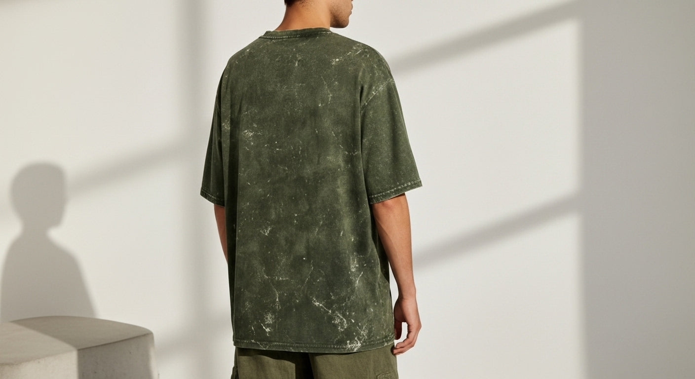 Person wearing a green t-shirt against a white wall