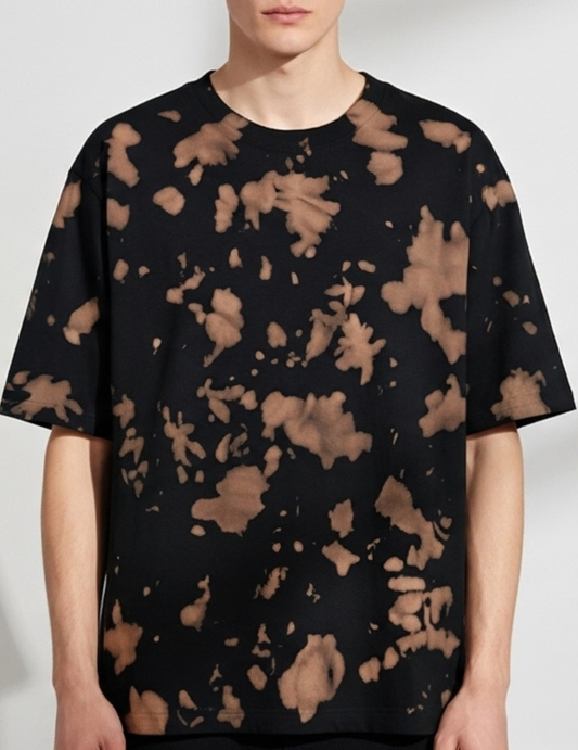 Black t-shirt with brown abstract pattern worn by a person on a white background