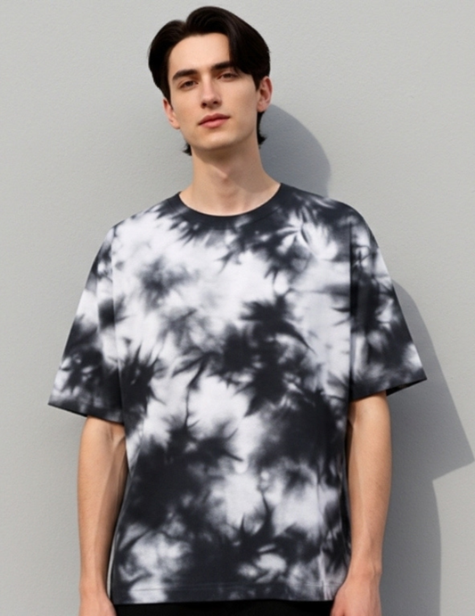 Person wearing a black and white tie-dye t-shirt against a gray background