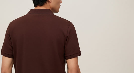 Man wearing a brown polo shirt against a plain background