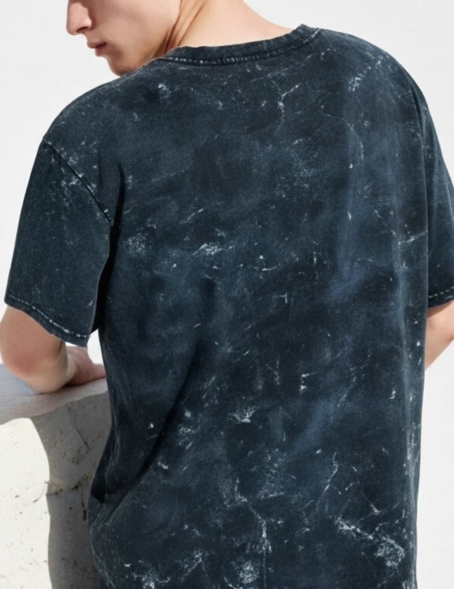 Person wearing a dark blue distressed t-shirt against a white background