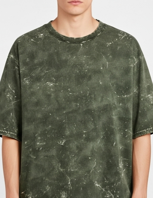Person wearing a green marble patterned t-shirt on a plain background
