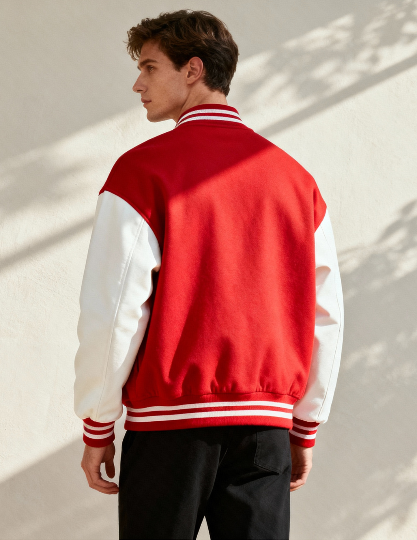 Person wearing a red and white varsity jacket against a light background