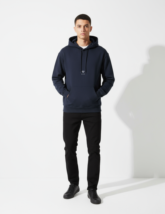 Man wearing a navy hoodie and black pants on a white background