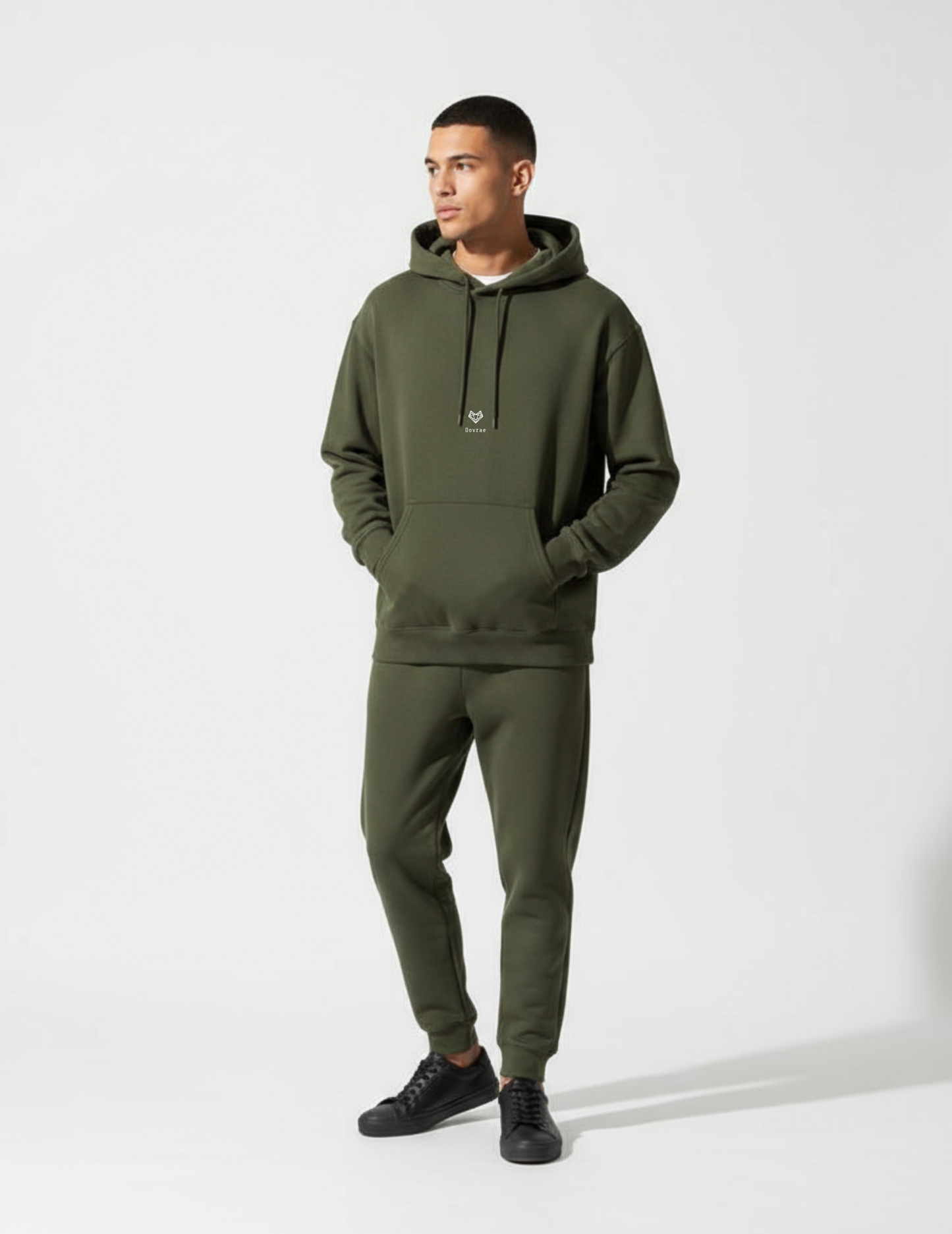 Man wearing a green hoodie and jogger pants on a white background